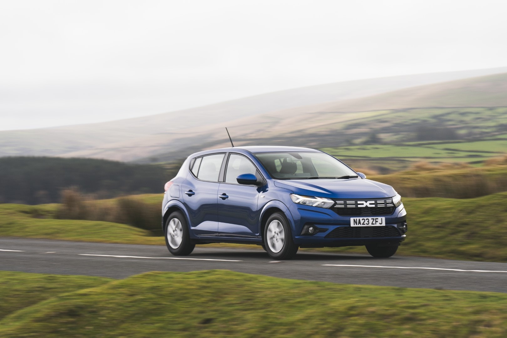 Dacia Sandero en carretera, mostrando líneas y postura dinámica.