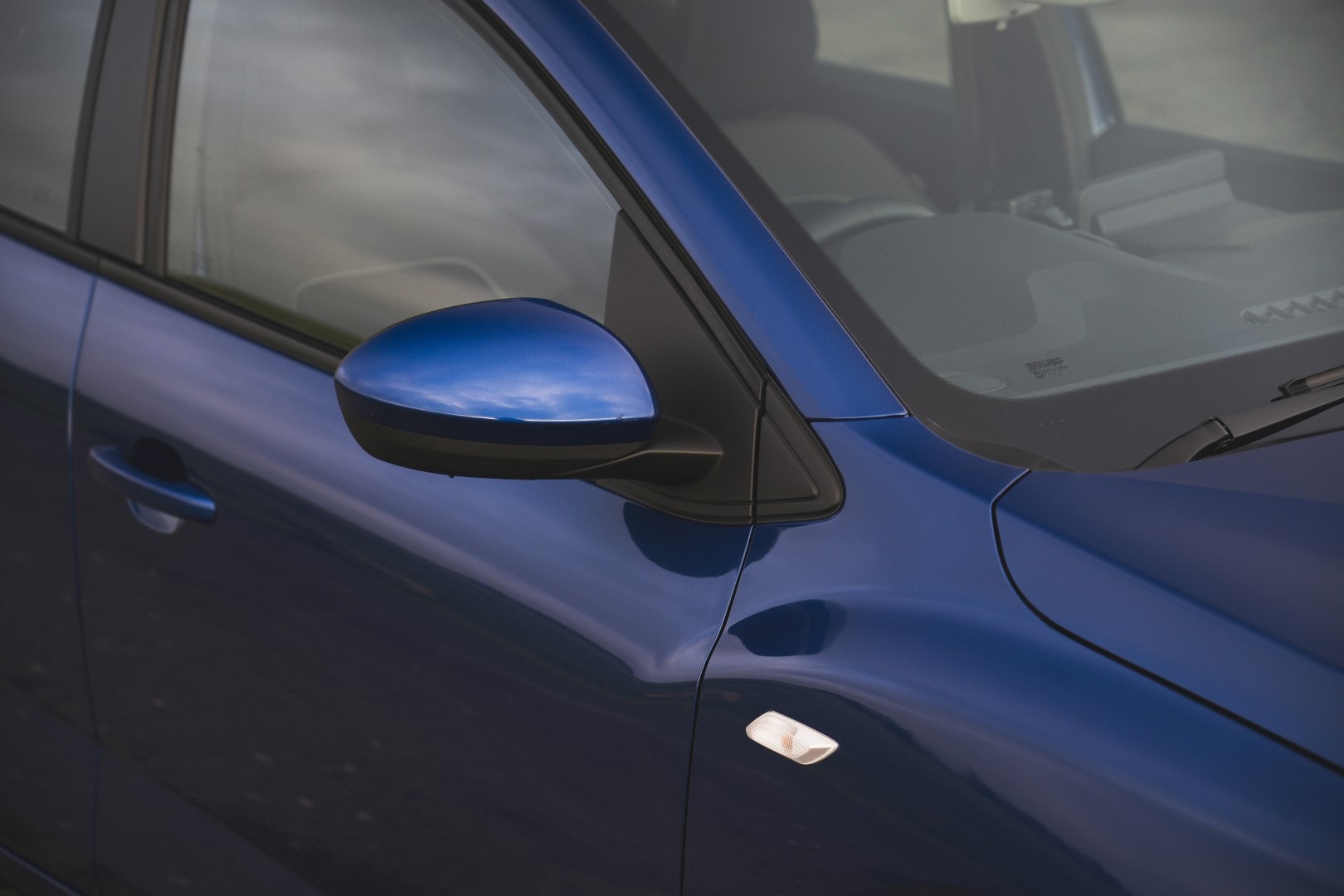 Detalle del espejo retrovisor del Dacia Sandero, mostrando su diseño y color.