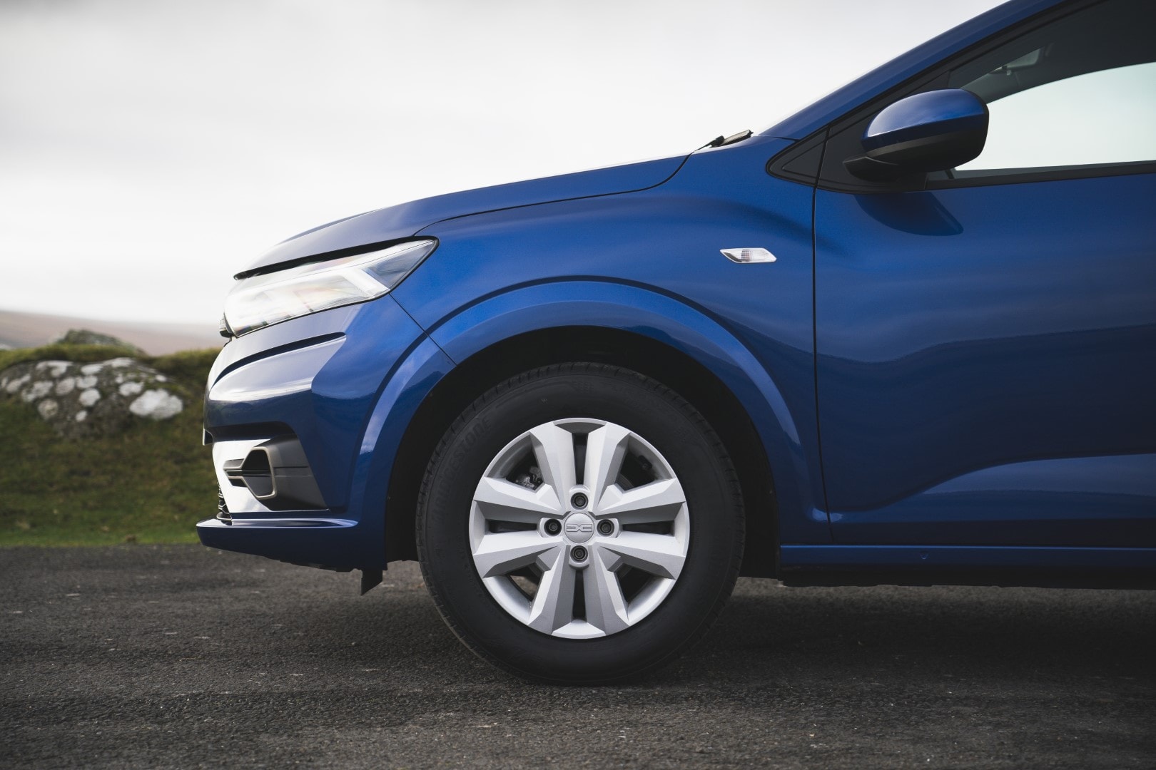 Imagen enfocando la rueda y parte de la carrocería lateral del Sandero.