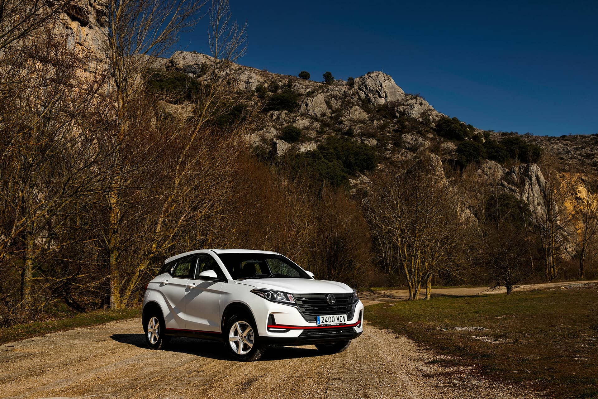 Vista lateral delantera del DFSK 500 en un camino rural.