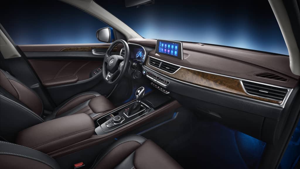 Cabina moderna del DFSK Glory 580 con enfoque en la consola central y asientos.