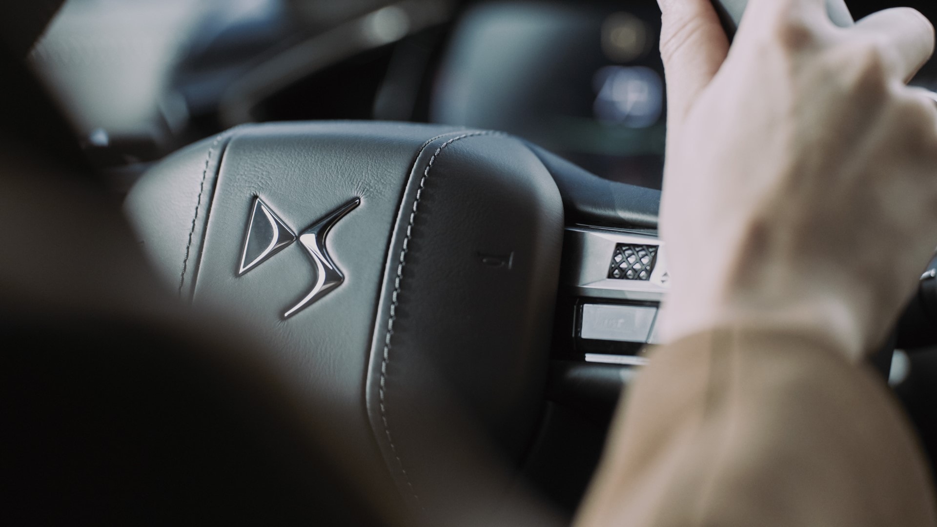 Vista del volante del DS 3 con el logotipo y mandos integrados.