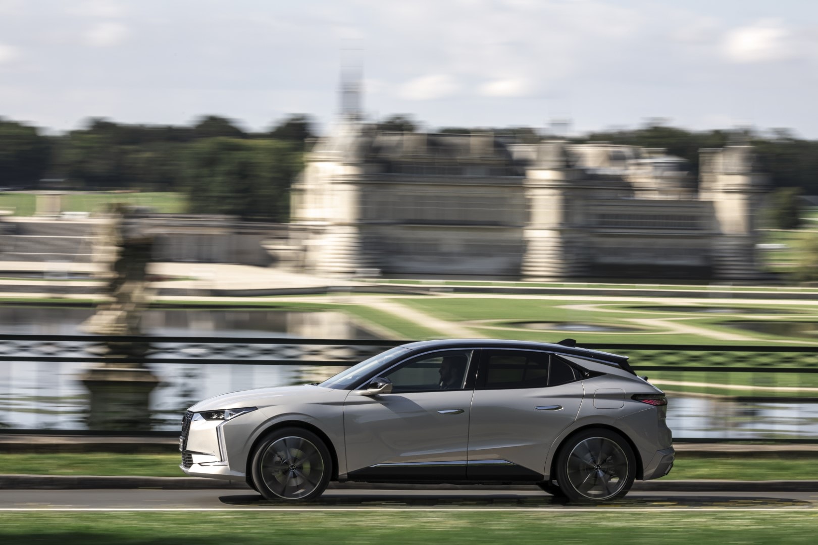 Vista lateral en movimiento del DS 4 híbrido, resaltando su elegancia y líneas fluidas.