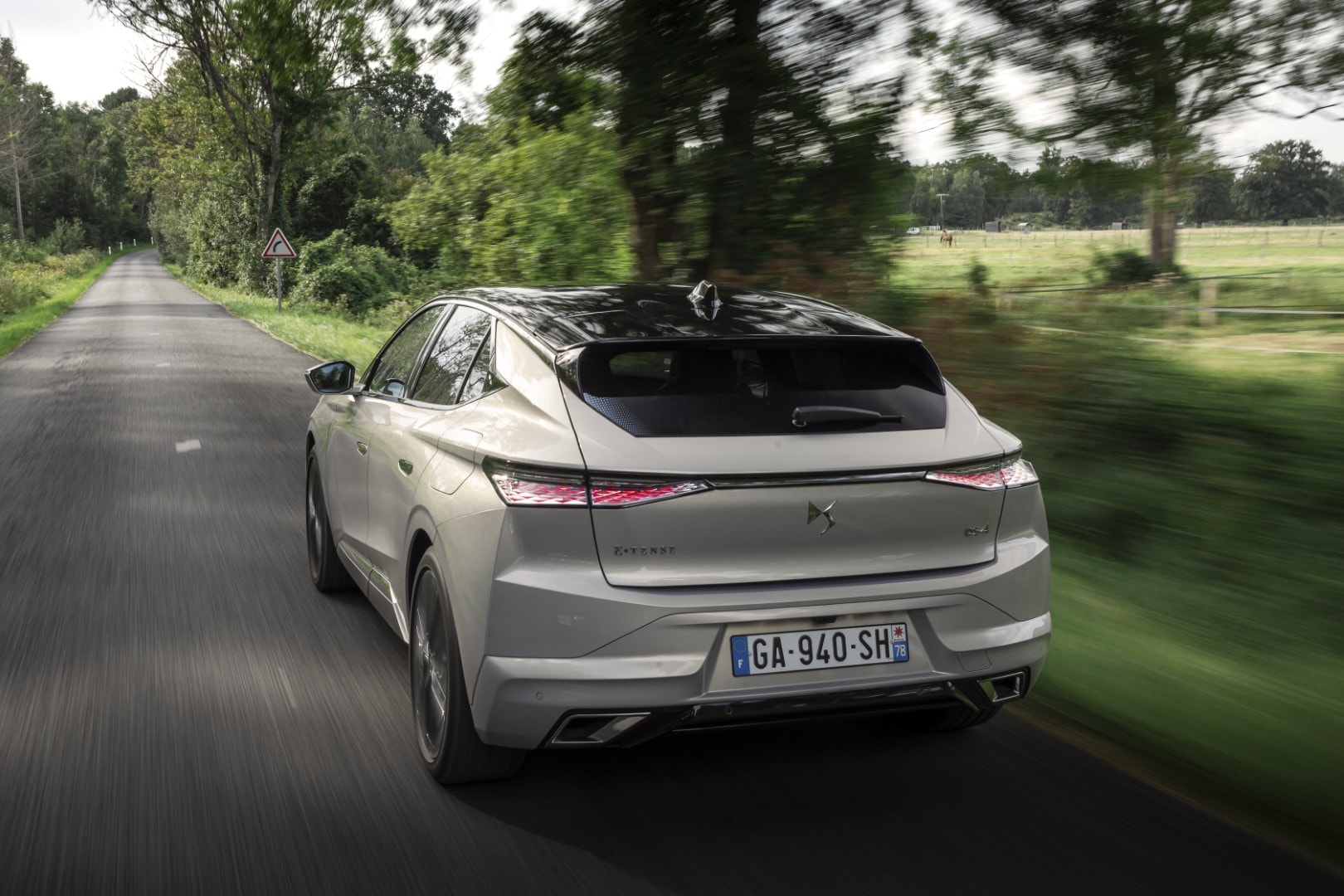 Perspectiva trasera y lateral del DS 4 híbrido, enfatizando su deportividad y diseño moderno.