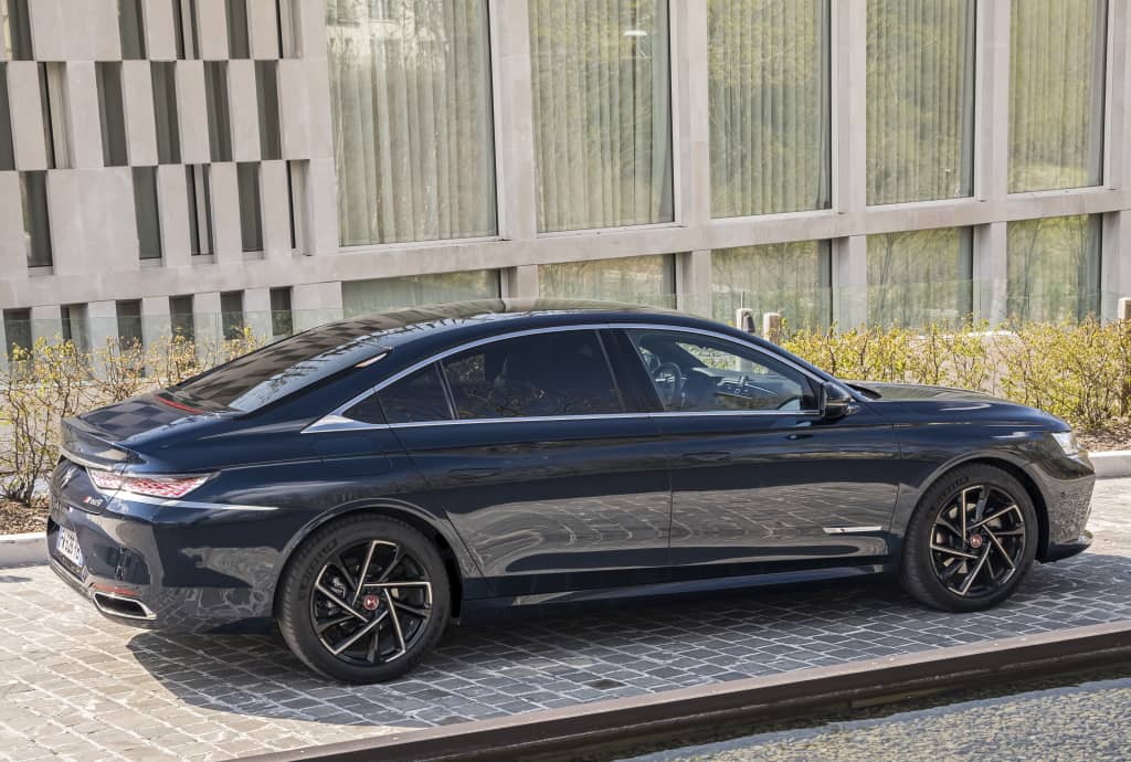 Perfil lateral del DS 9 híbrido aparcado, subrayando su diseño y llantas distintivas.