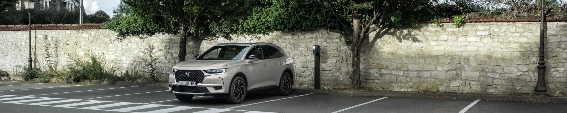 Vista lateral del DS7 Híbrido en un contexto urbano, resaltando su diseño y proporciones.