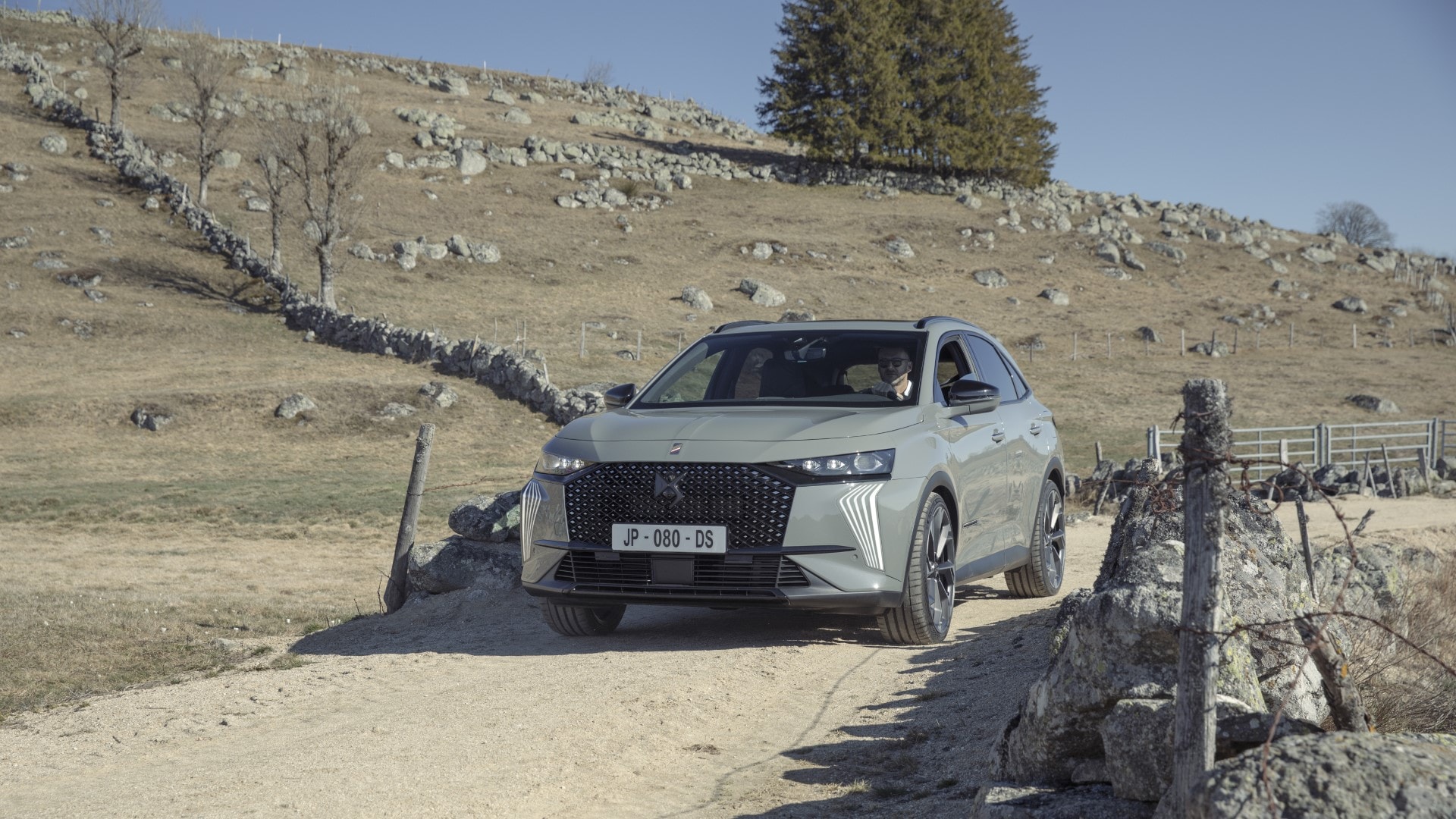 DS7 Híbrido en primer plano con un paisaje rural de fondo, destacando su presencia.