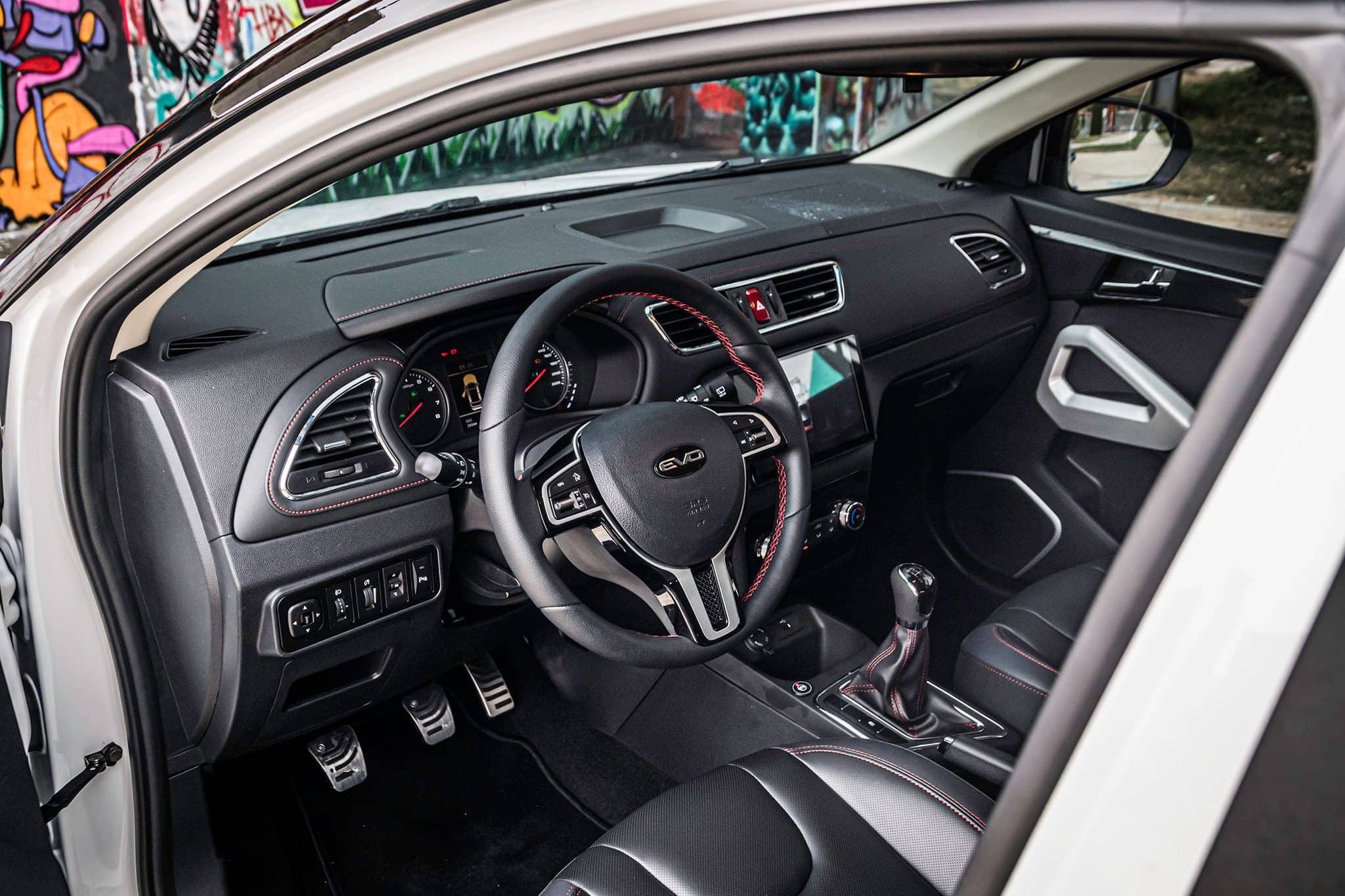 Habitáculo del EVO 3 con enfoque en el volante y los asientos, acabados de calidad.