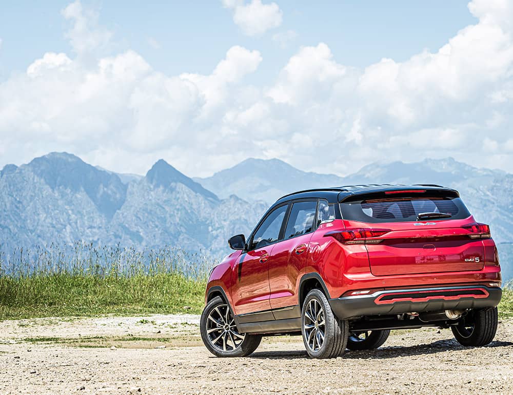 Toma trasera del Kia mostrando su diseño distintivo y su integración con la naturaleza montañosa.