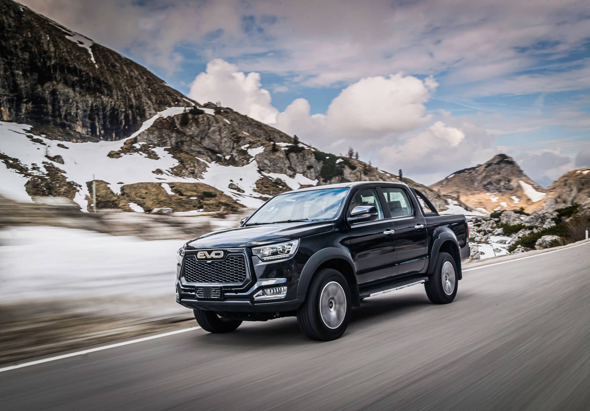 Vista dinámica del EVO Cross4 en movimiento por una carretera con nieve, transmite capacidad y desempeño.