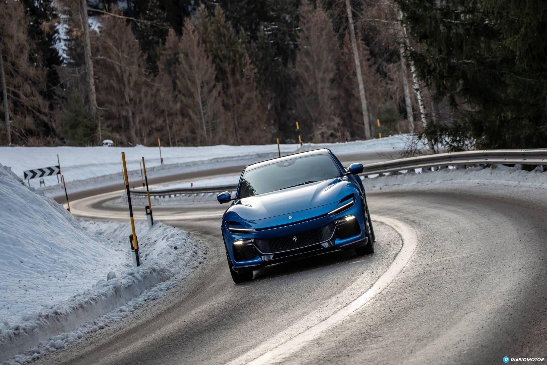 Ferrari Purosangue tomando una curva en carretera nevada, con foco en su frontal.
