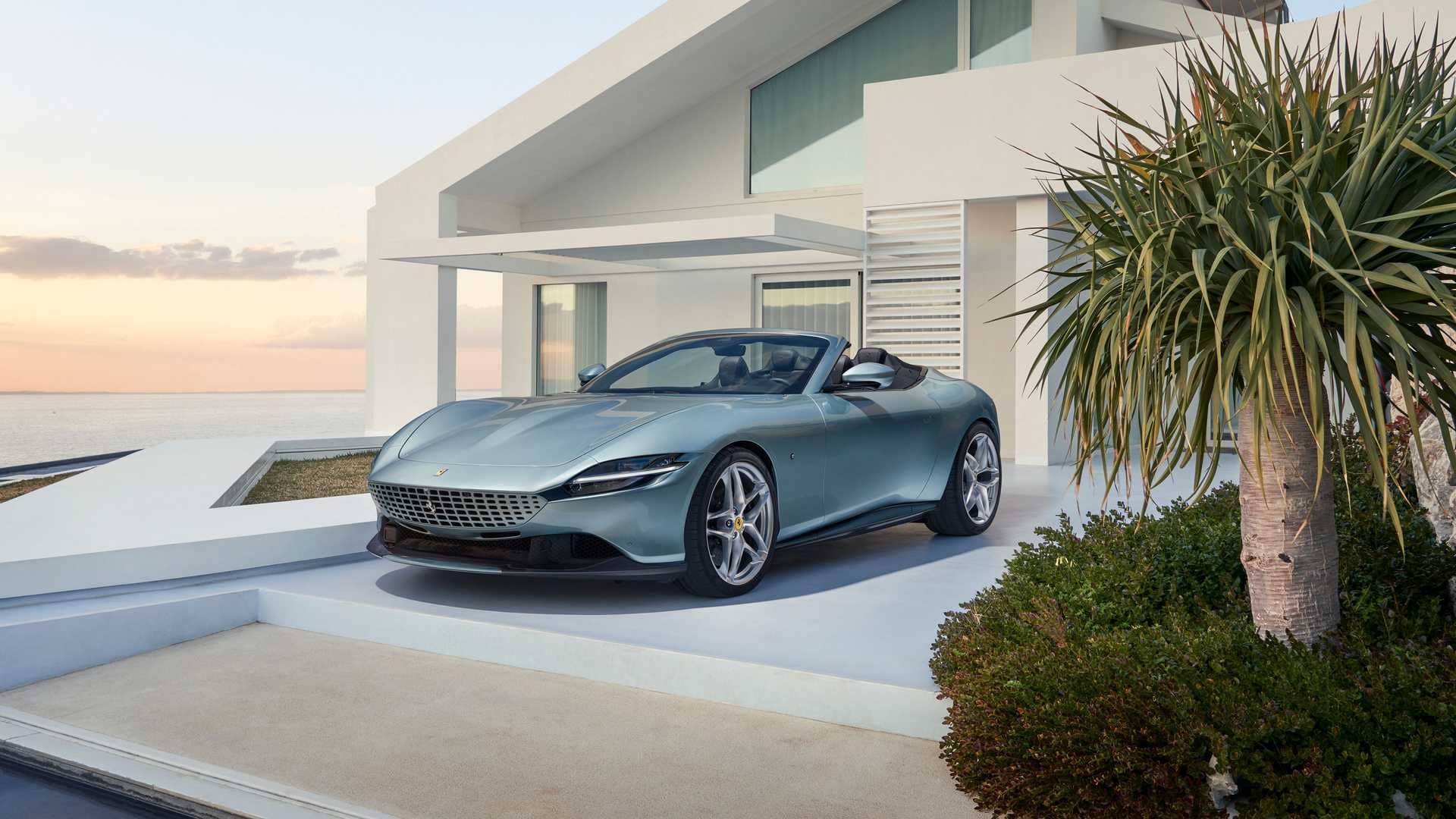Ferrari Roma Spider aparcado frente a una mansión contemporánea.