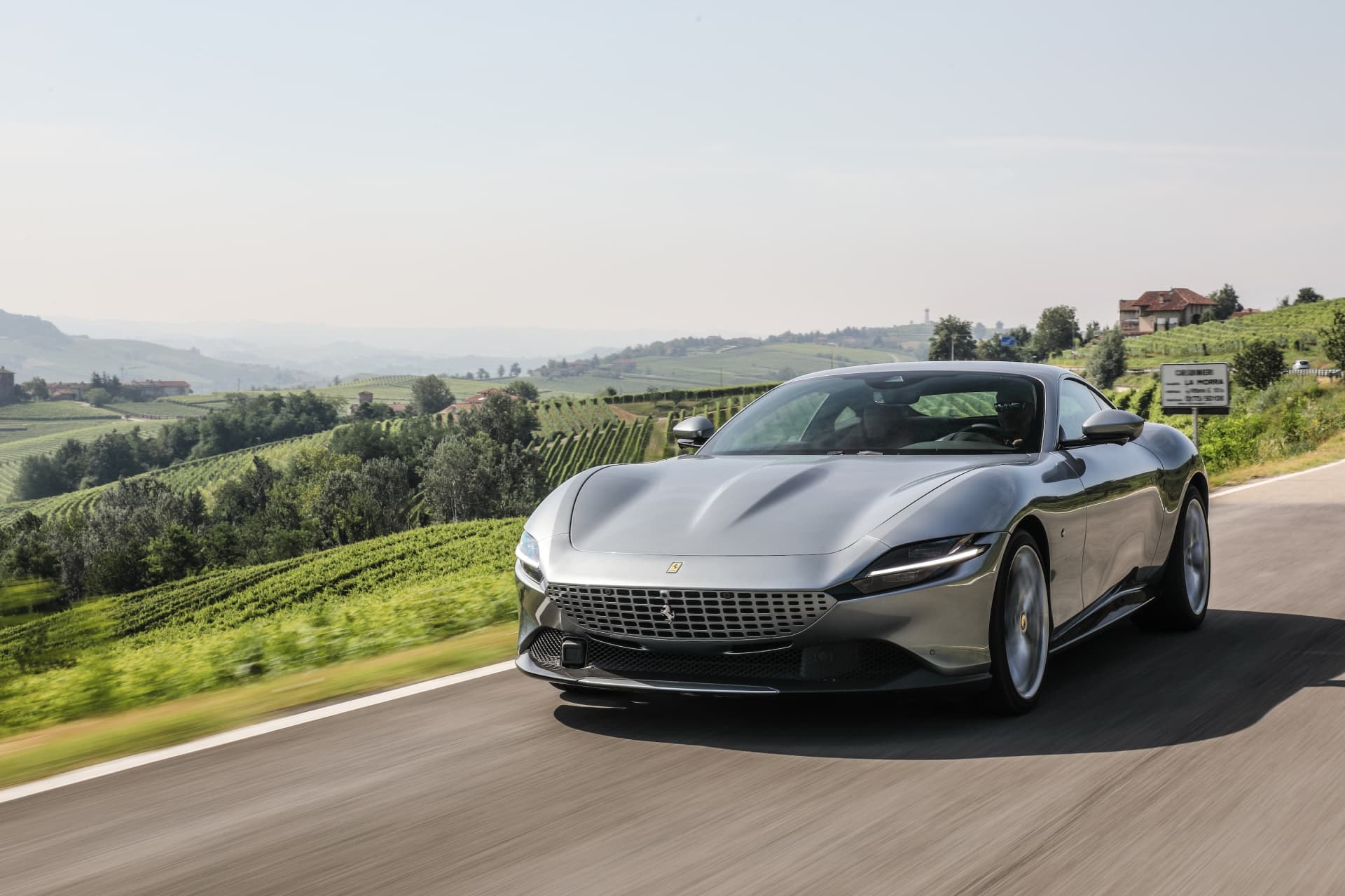 Vista dinámica del Ferrari Roma en carretera, destacando su elegante frontal.