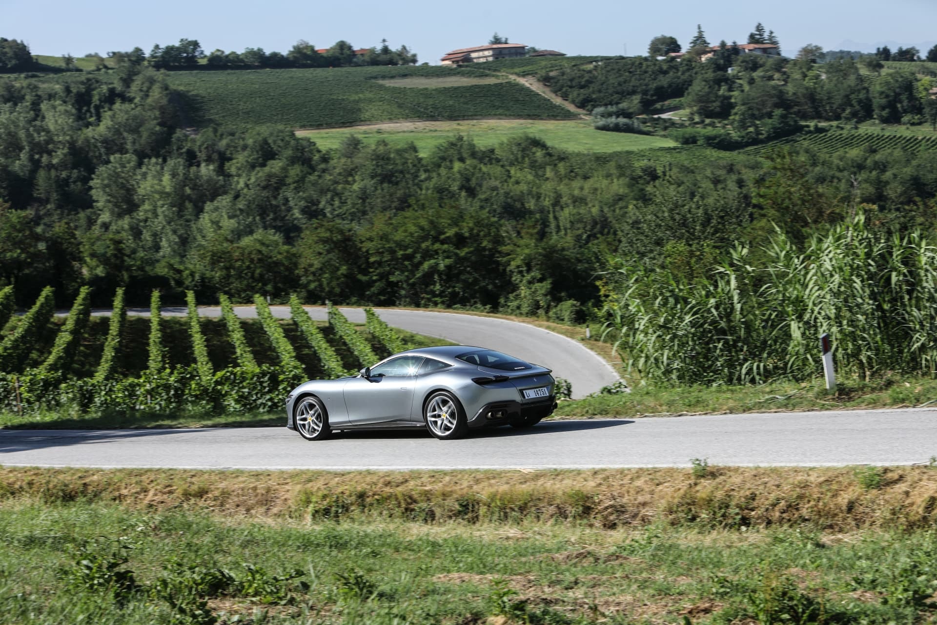 Vista lateral del Ferrari Roma con un hermoso paisaje al fondo.