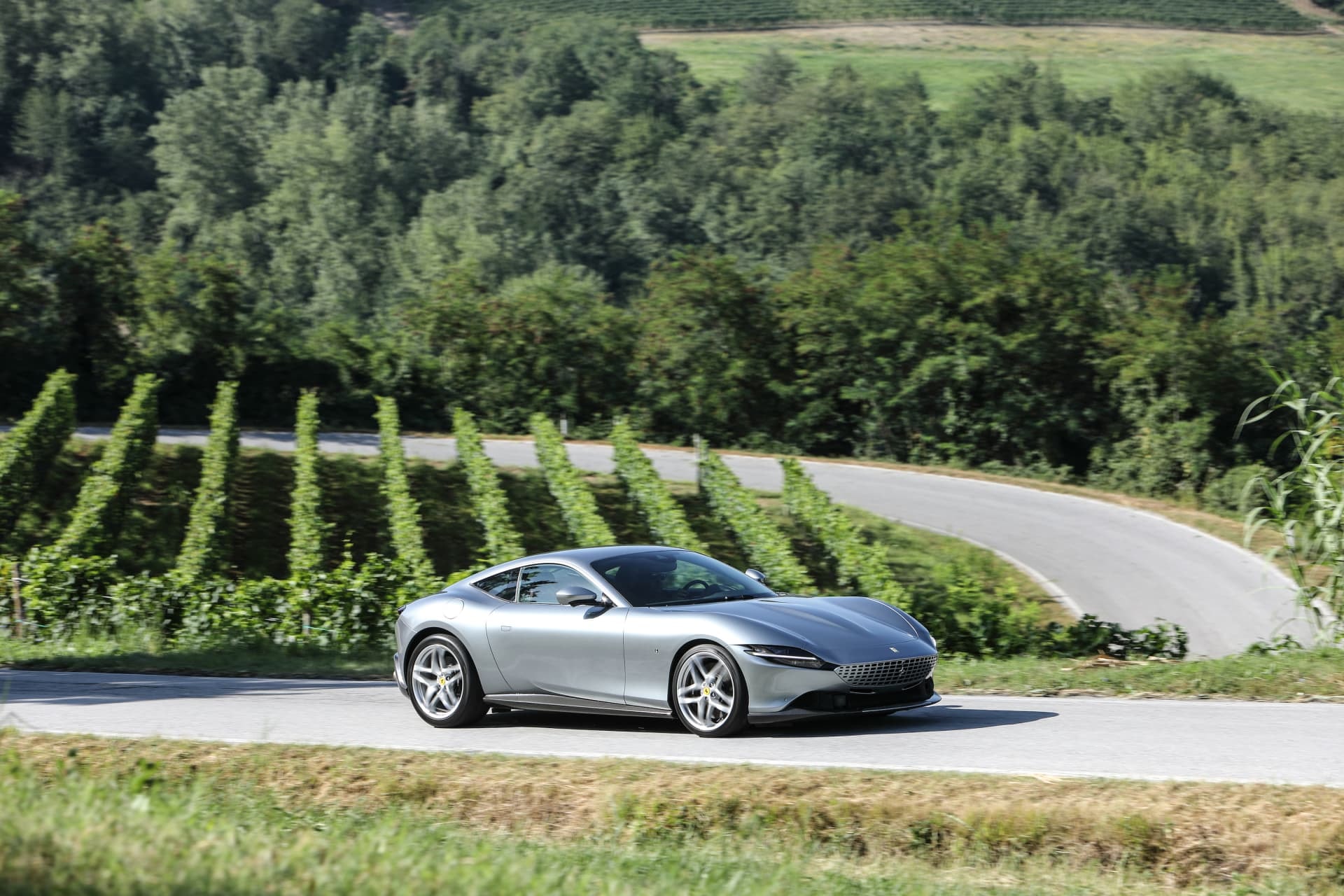 Vista lateral del Ferrari Roma circulando por carretera.