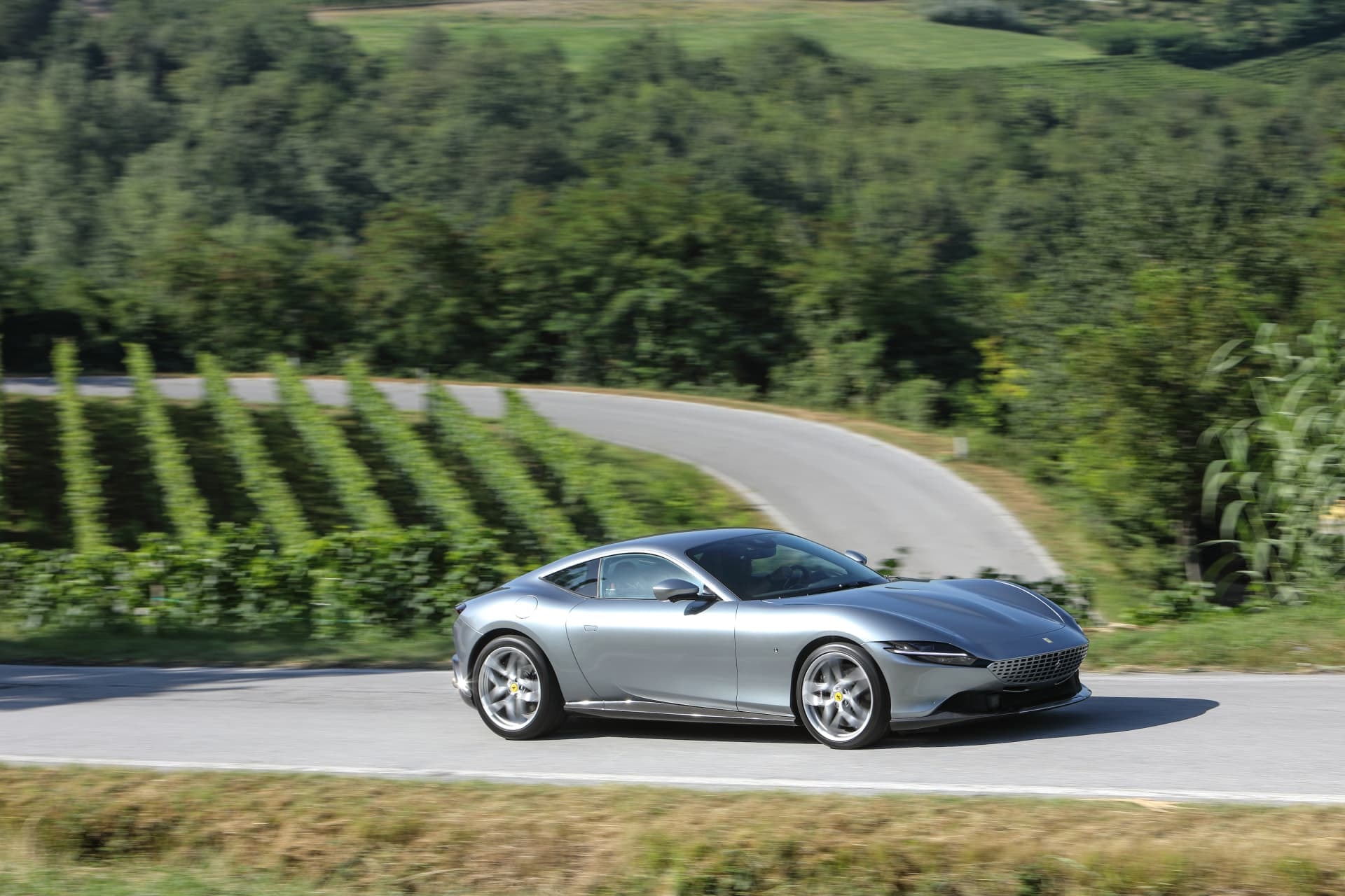 Ferrari Roma recorriendo una ruta serpenteante, destacando su silueta.