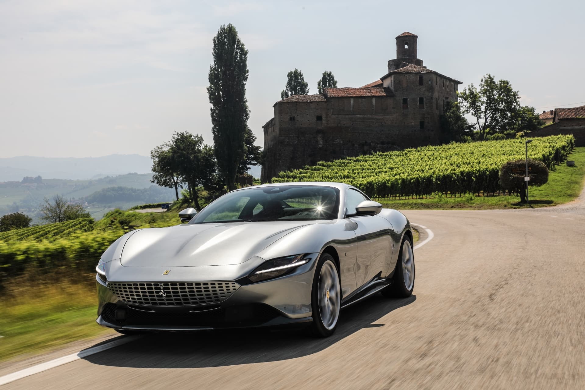 Vista frontal del Ferrari Roma con un castillo de fondo, destacando su distinción.