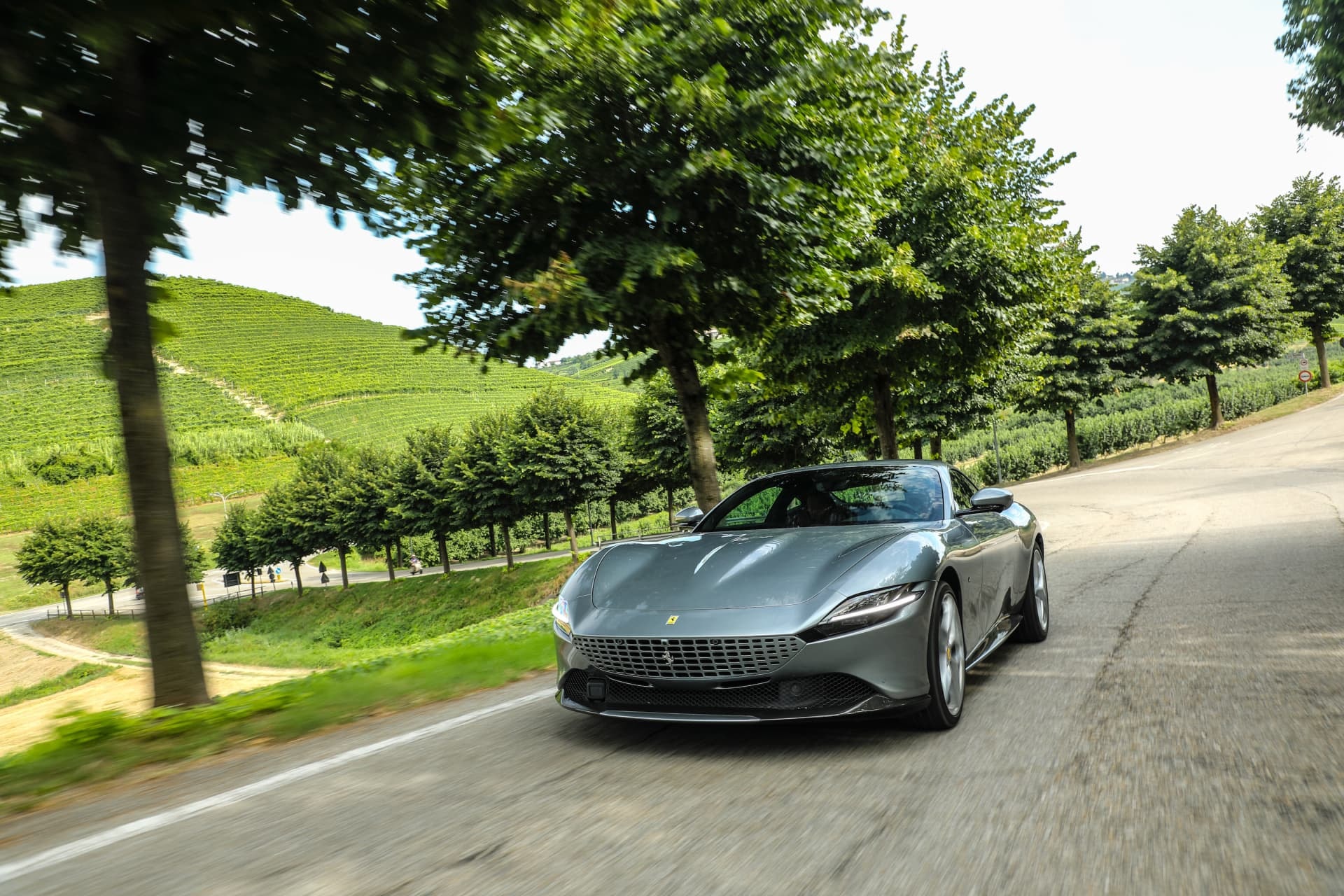 Ferrari Roma capturado en movimiento desde una perspectiva frontal dinámica.