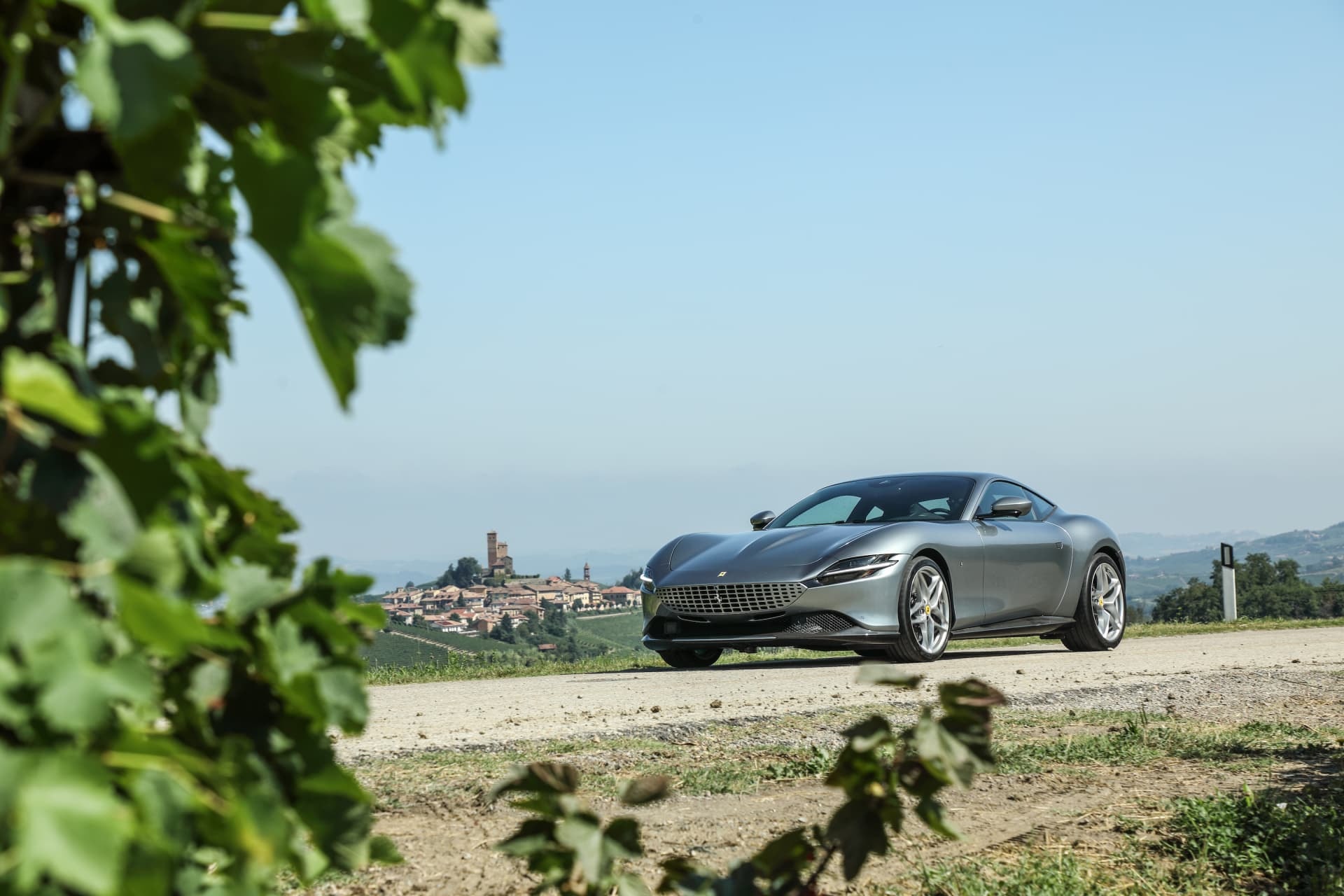 Ferrari Roma con paisaje campestre, enfatiza su diseño.