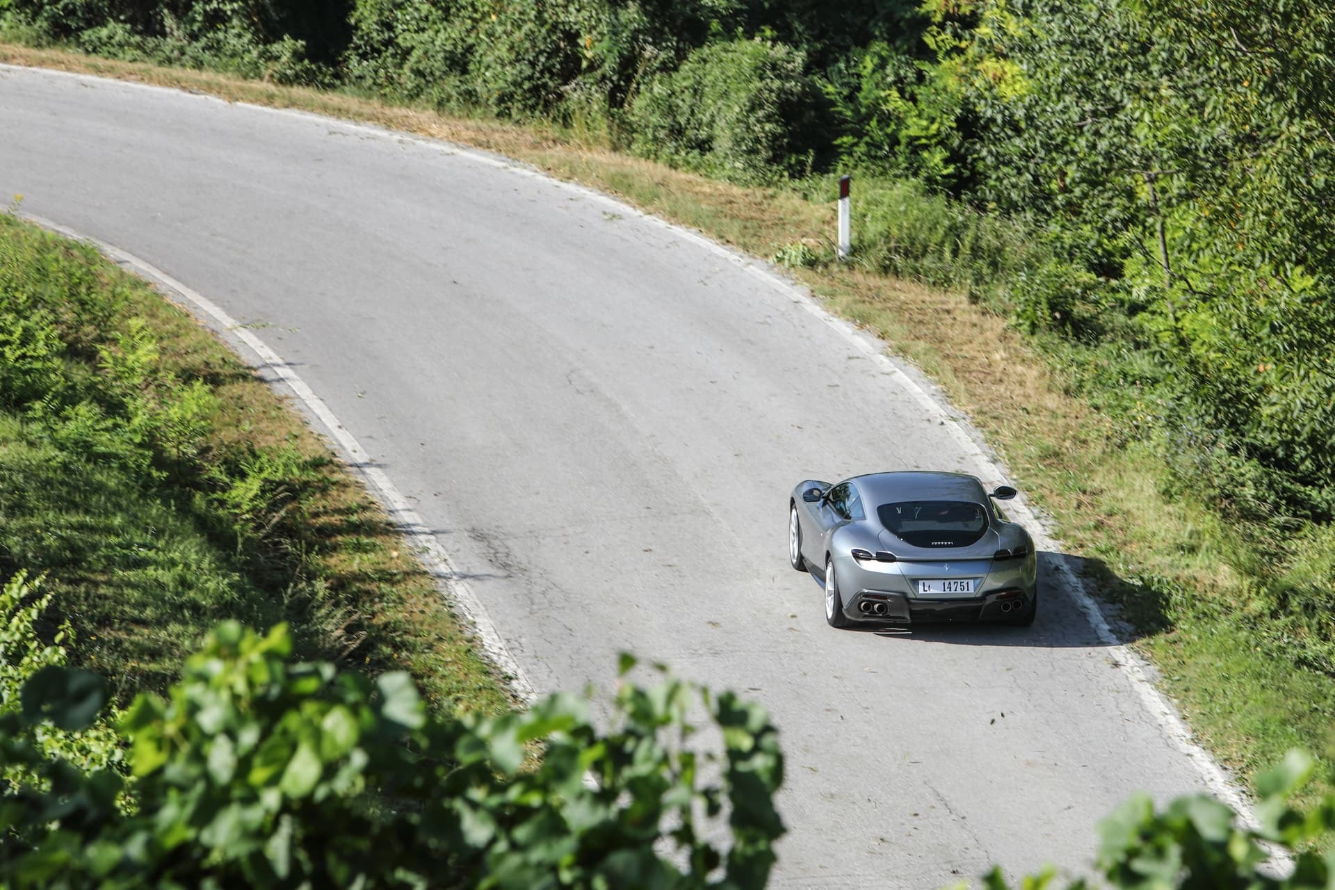 Imagen lateral del Ferrari Roma tomando una curva, perfil aerodinámico en acción.