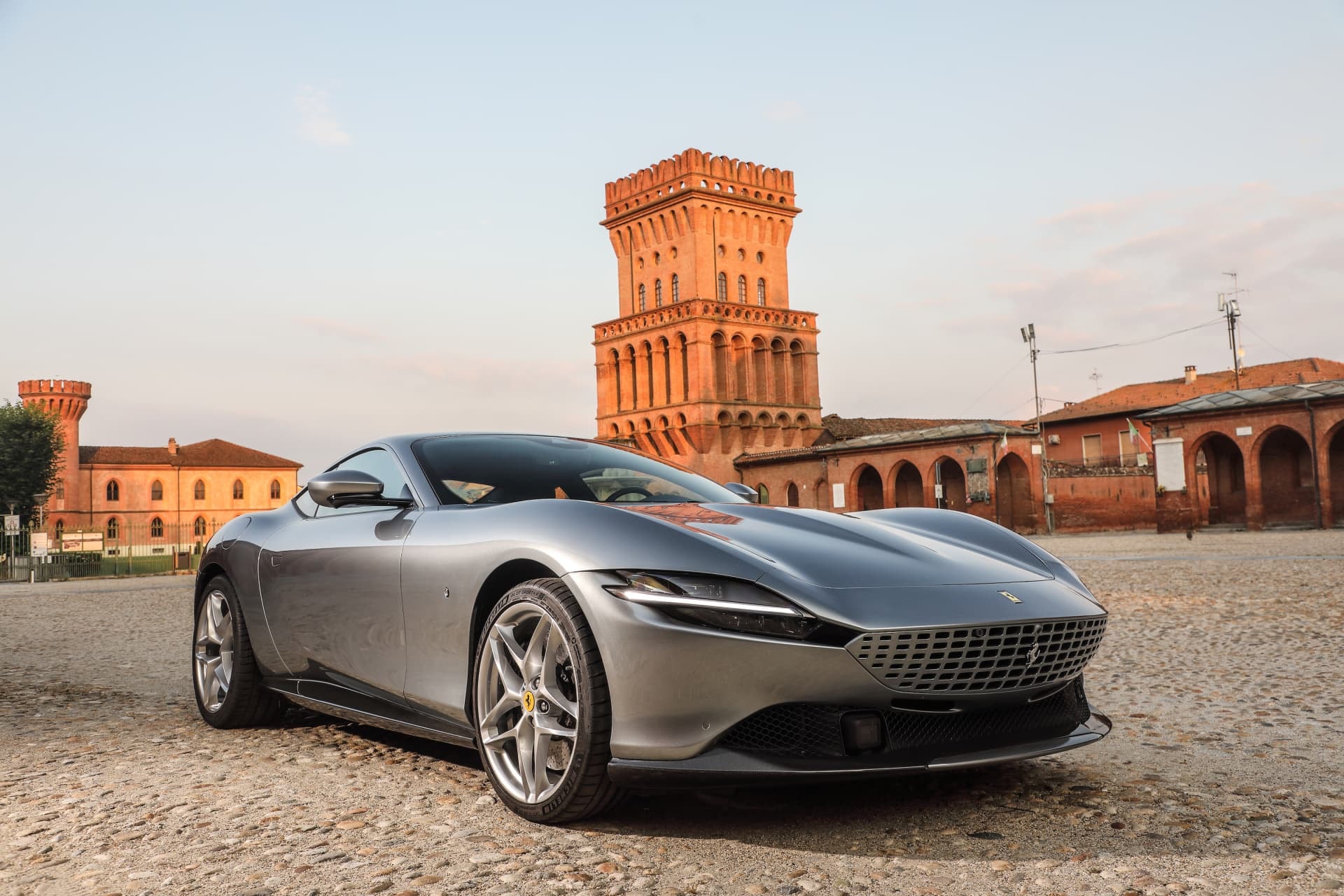 Imagen del Ferrari Roma frente a un histórico edificio, mostrando su imponente presencia.