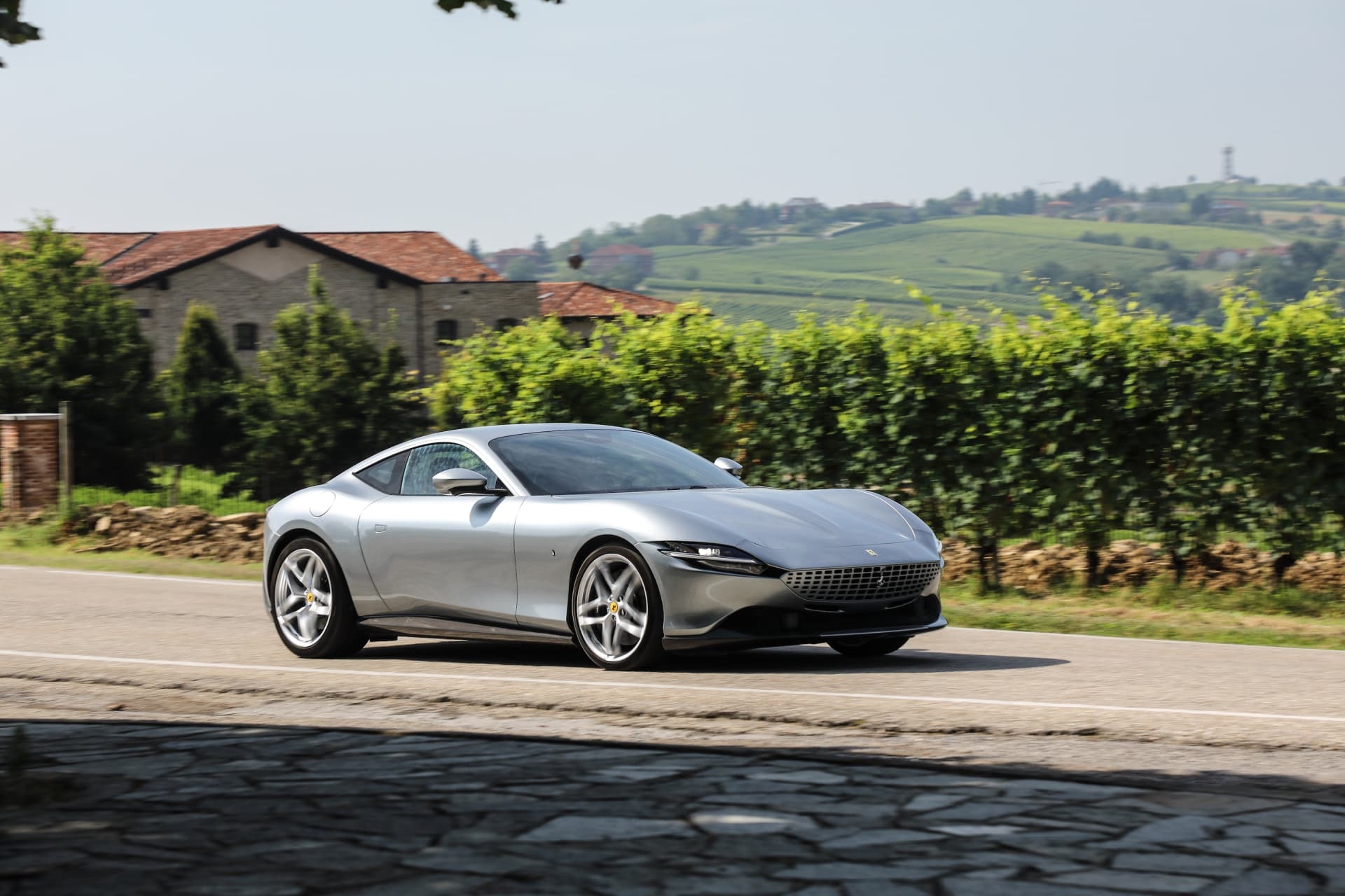 El Ferrari Roma mostrando su silueta dinámica en un contexto de carretera rural.