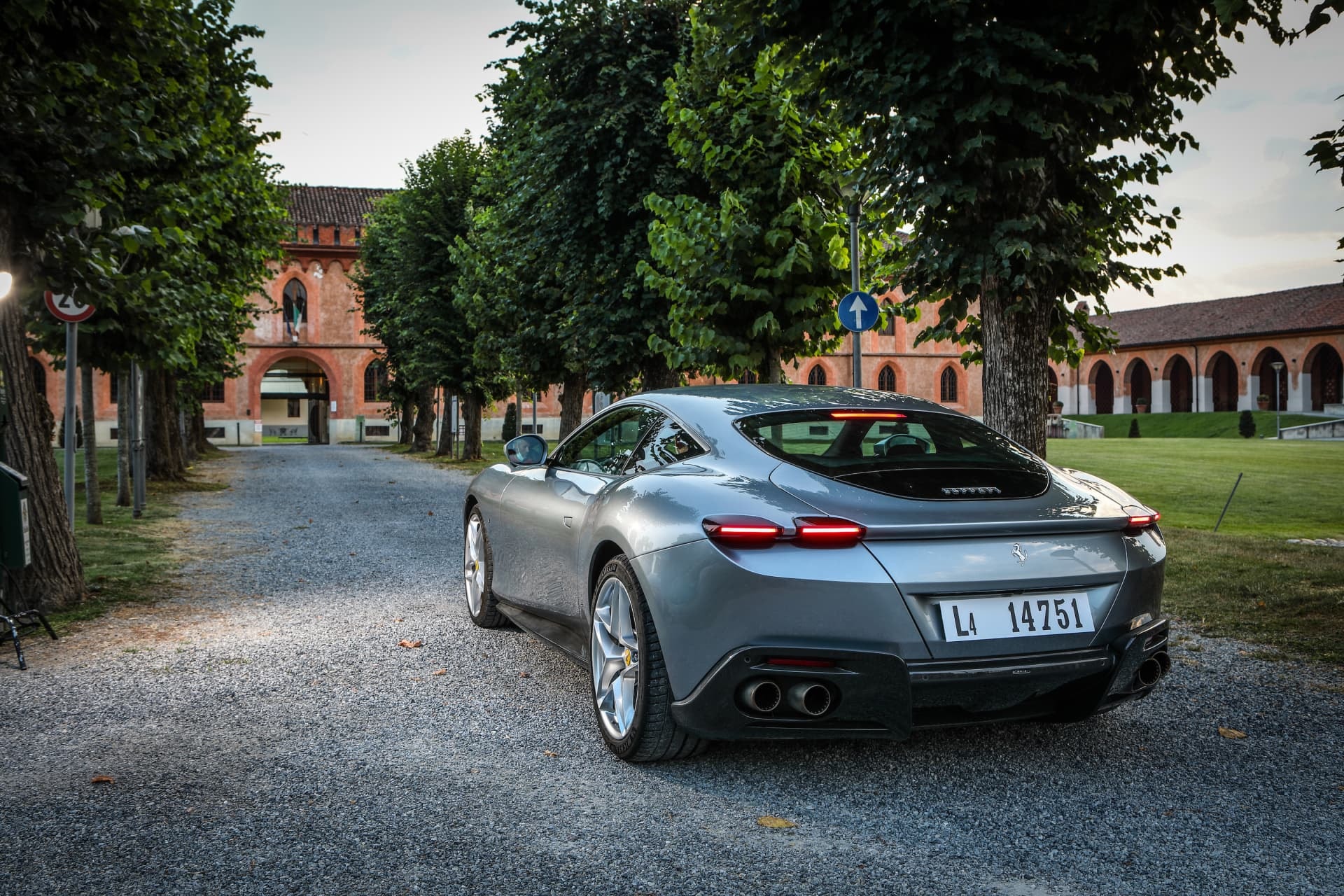 Trasera del Roma con detalle de sus escapes y grupo óptico, en escenario urbano.