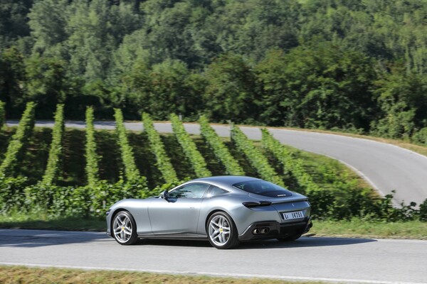 Toma de la trasera y lateral del Ferrari Roma en una carretera con curvas Toma de la trasera y lateral del Ferrari Roma en una carretera con curvas