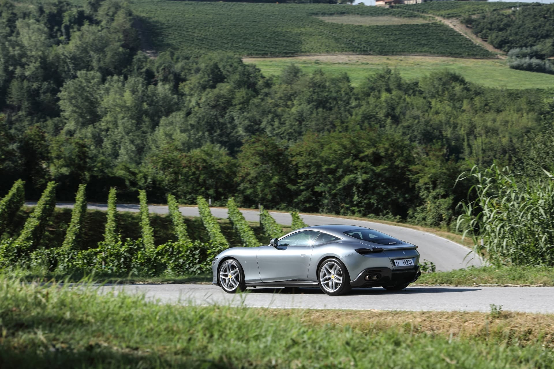 Angulo trasero y lateral del Ferrari Roma al transitar una curva, feliz matrimonio de estilo y potencia.