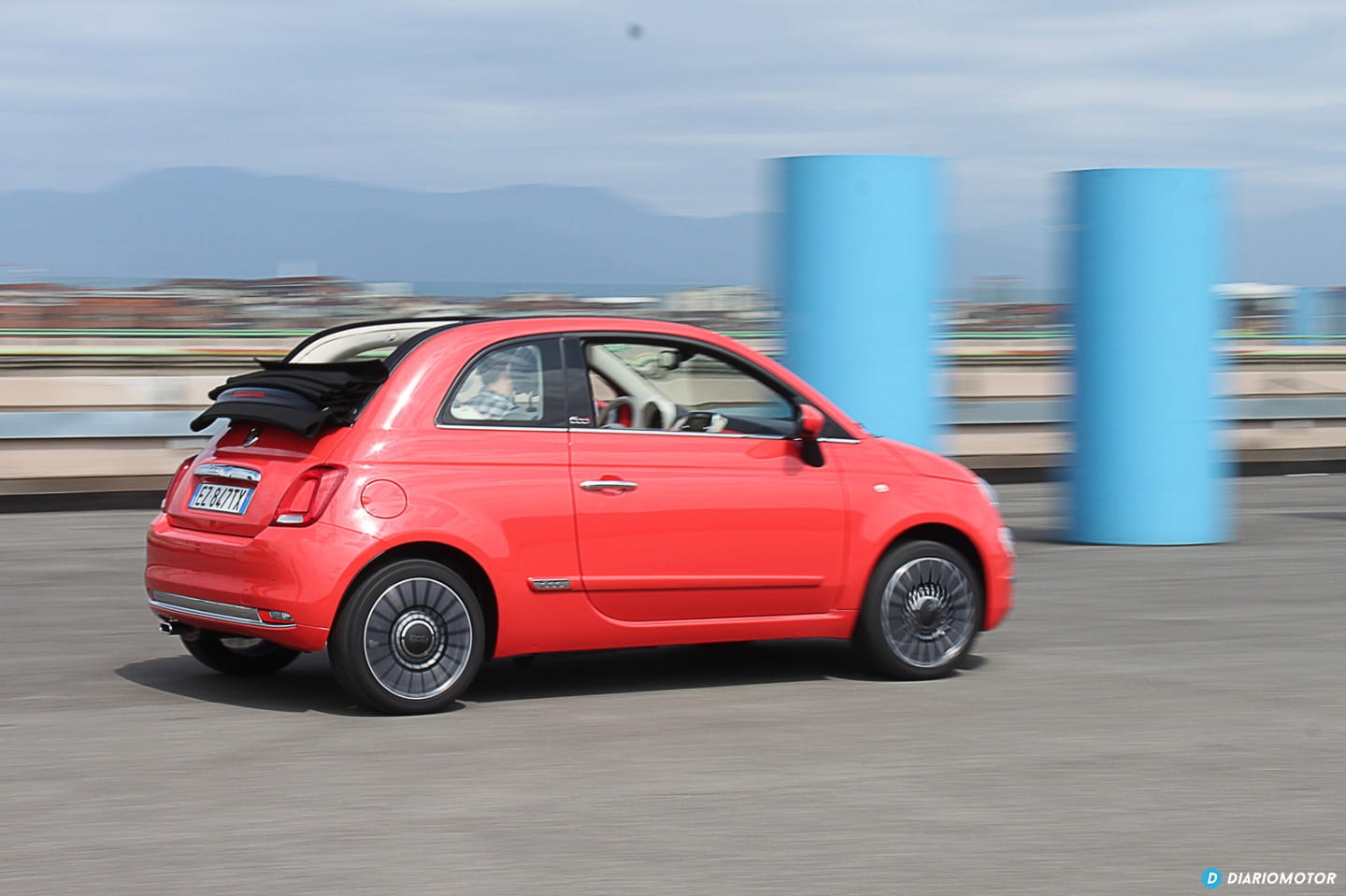 Fiat 500 capturado en movimiento, mostrando su perfil lateral.