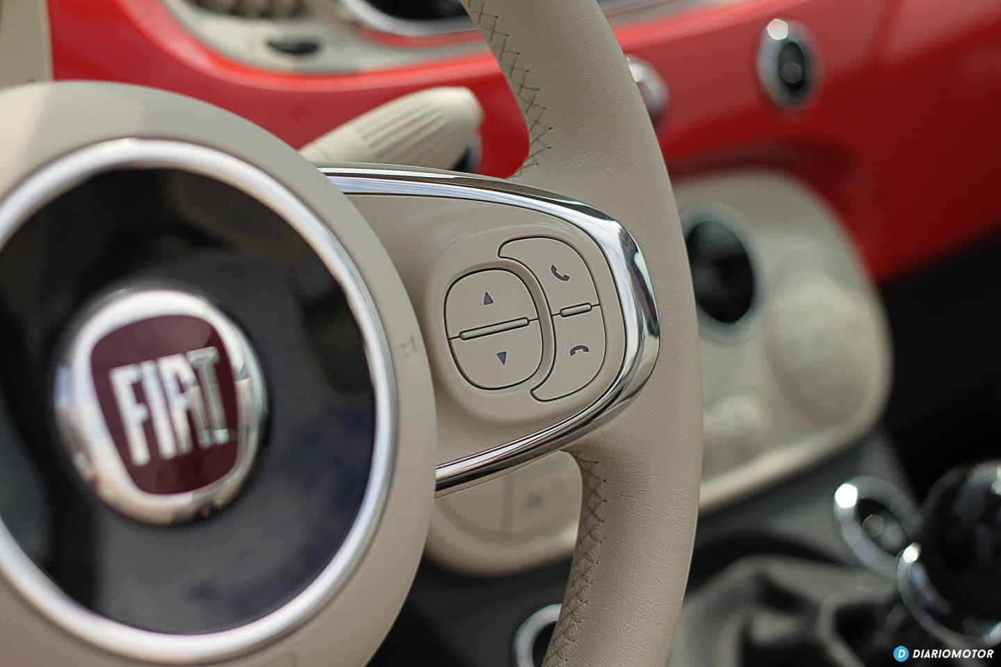 Volante con controles integrados y logo Fiat al centro.