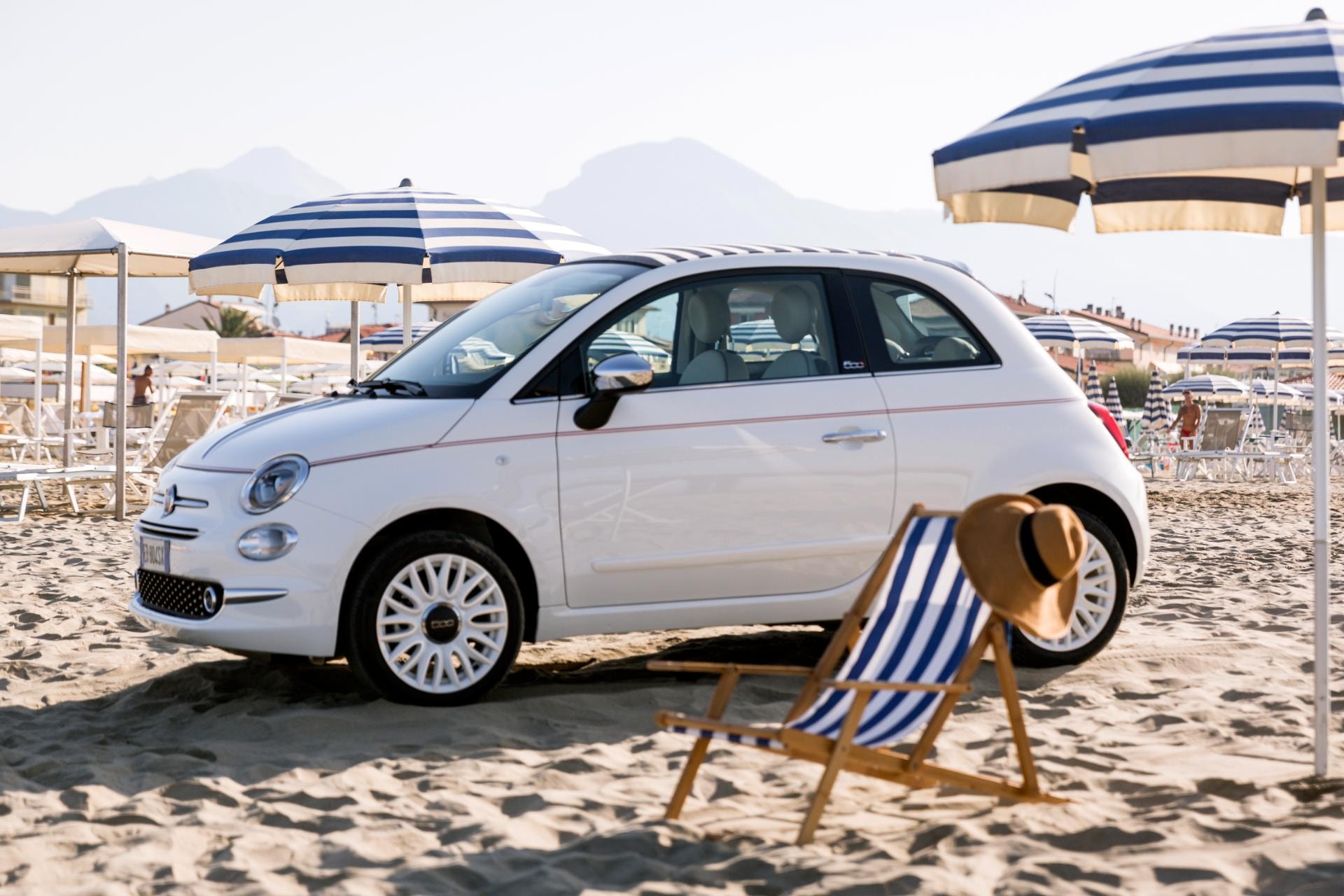 Fiat 500C estacionado en la playa, reflejo del estilo de vida casual.