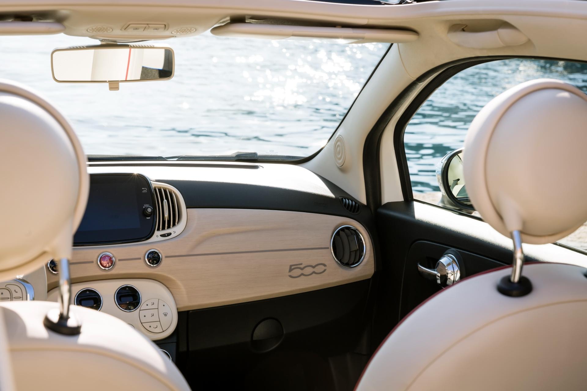 Vista interior del Fiat 500C destacando su tablero y volante.