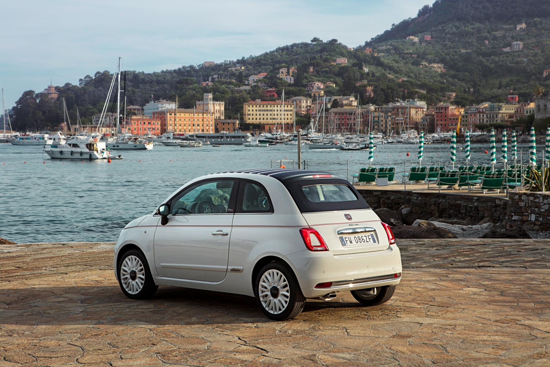 Vista trasera del Fiat 500C estacionado en un pintoresco puerto italiano.
