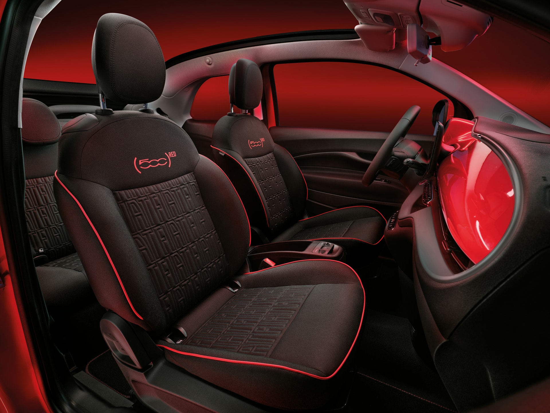 Interior del Fiat 500e con asientos en contraste rojo y negro, específicos de la versión eléctrica.