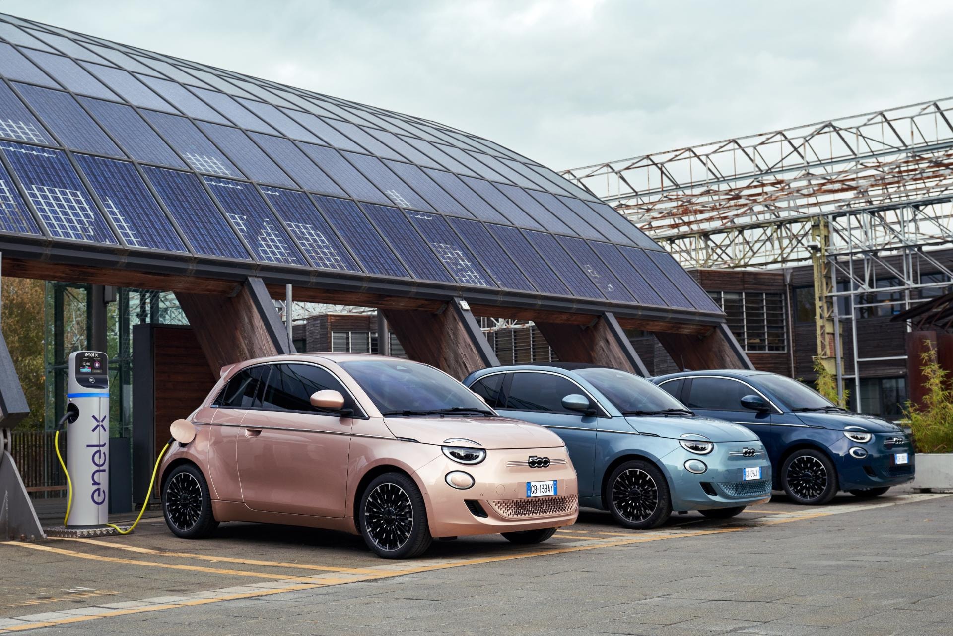 Los Fiat 500e cargando en una estación de carga solar, enfatizando su sostenibilidad.