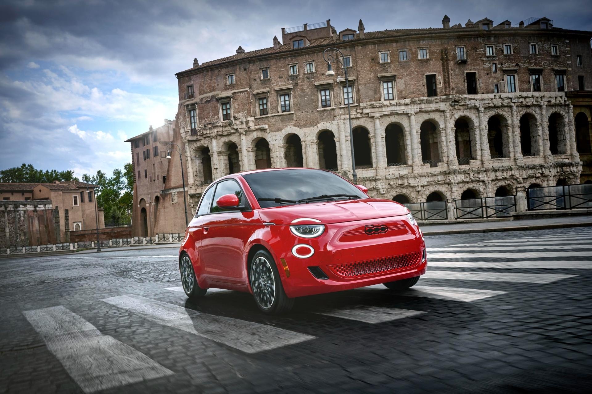 El Fiat 500e posa ante un emblemático monumento romano, resaltando su diseño.