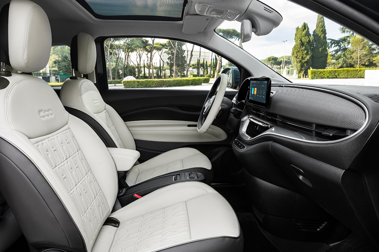 Interior del Fiat 500e con asientos de cuero blanco y detalle de costuras.