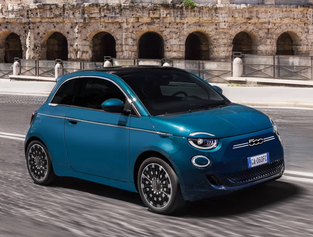 Perfil del Fiat 500e con el Coliseo en el fondo, exhibiendo su diseño urbano y elegante.