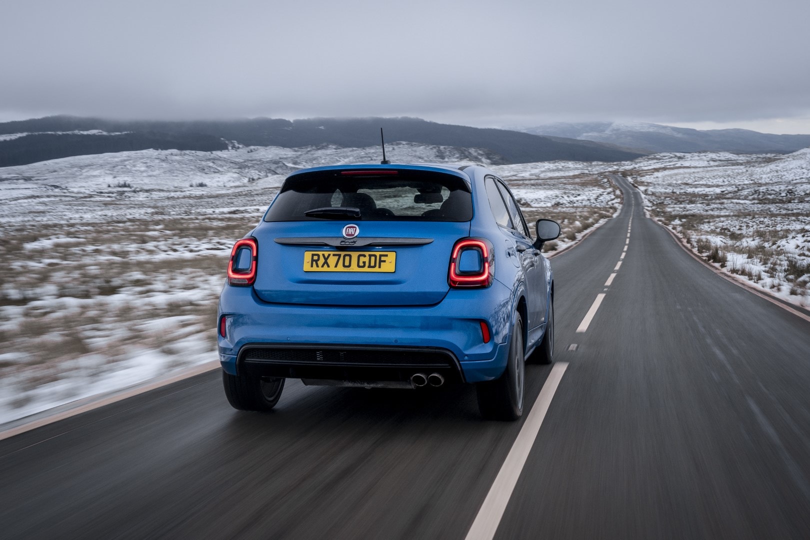 Perspectiva trasera del Fiat 500X en movimiento, mostrando dinamismo