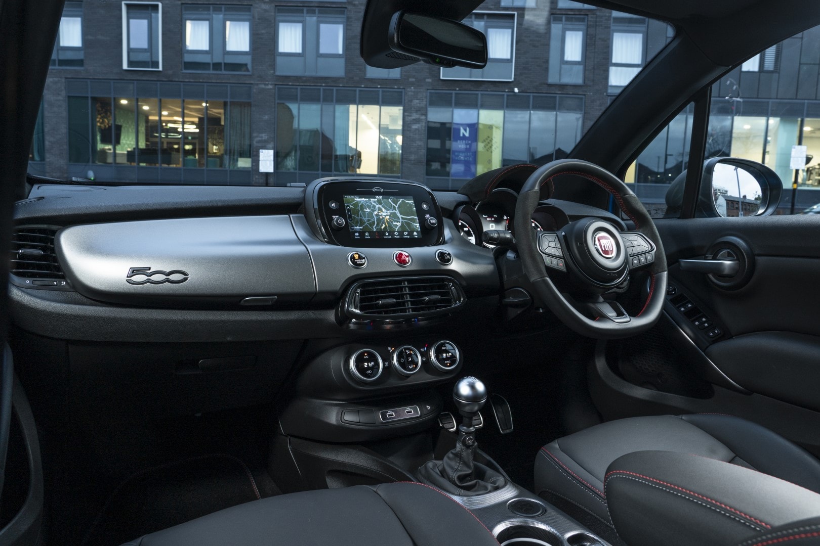 Vista amplia del interior Fiat 500X, mostrando consola y asientos en detalle
