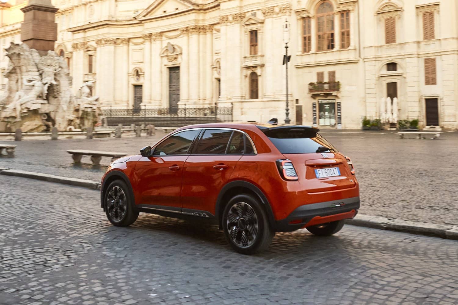 El diseño elegante de la parte trasera y lateral del Fiat 600e, mostrando faros y carrocería.