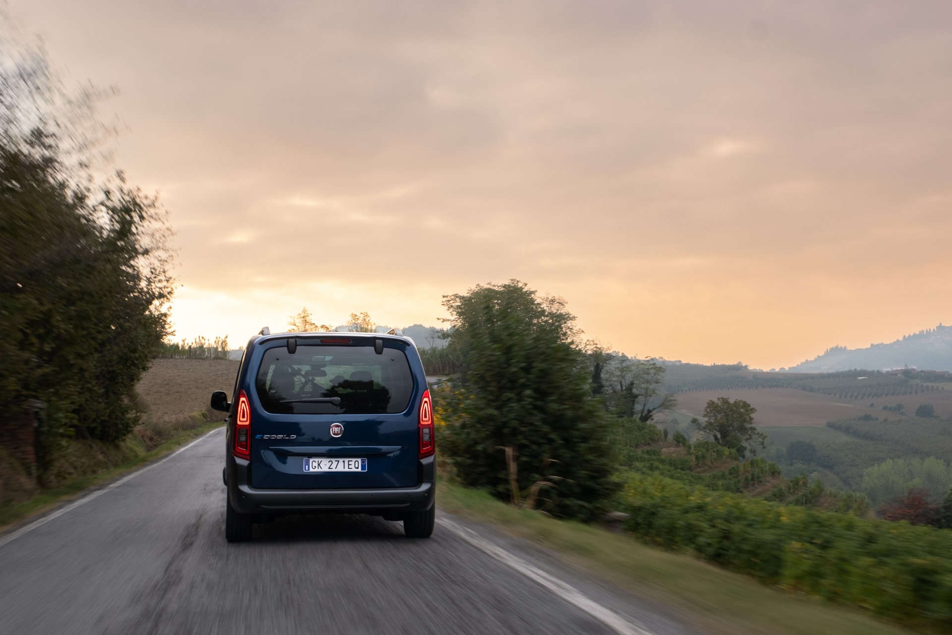 Imagen trasera del Fiat Dobló eléctrico en ruta, con un paisaje de fondo.