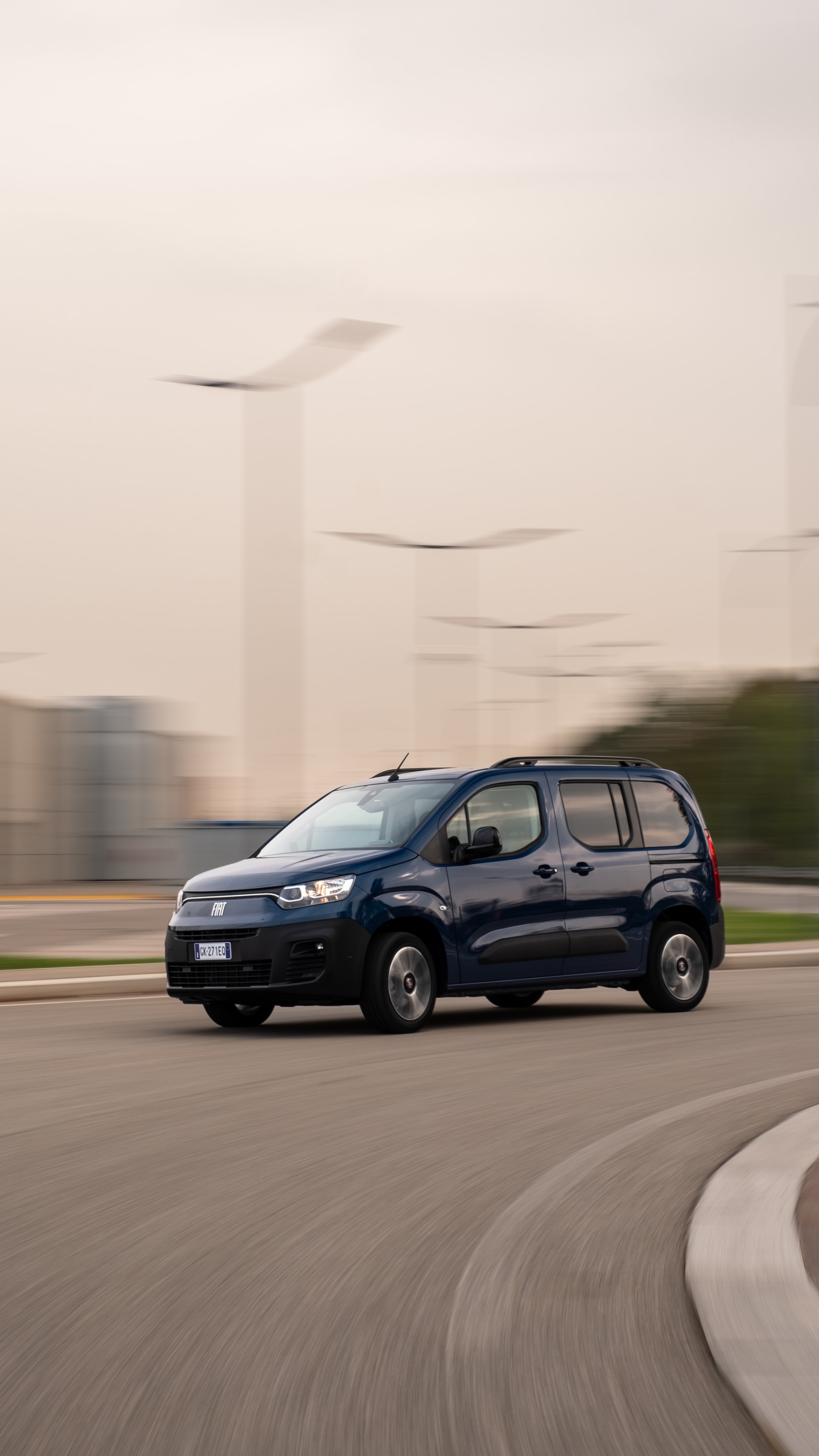 El Fiat Dobló eléctrico rodando con un paisaje dinámico de fondo.