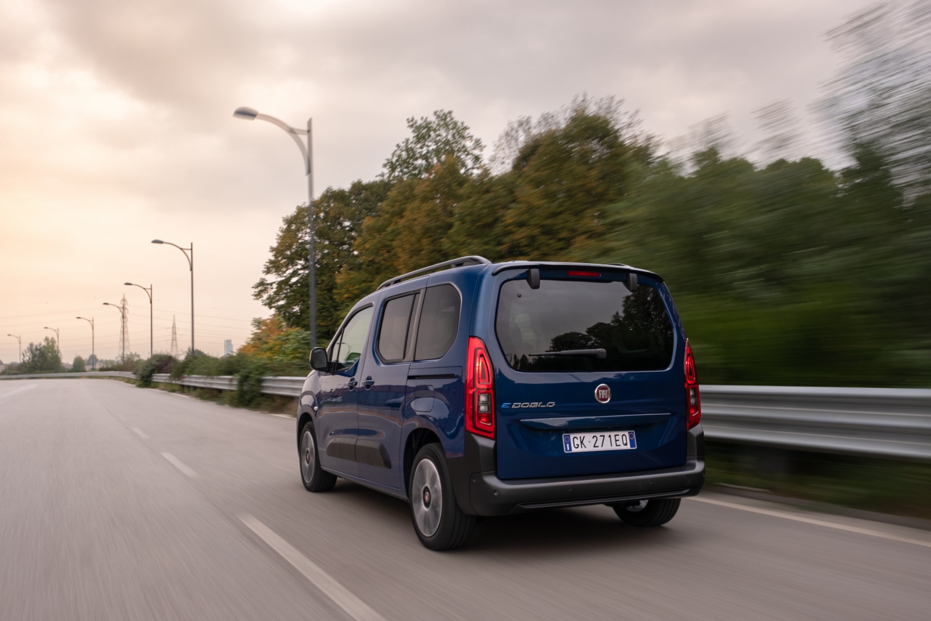 Vista dinámica trasera y lateral del Fiat Doblò eléctrico rodando.
