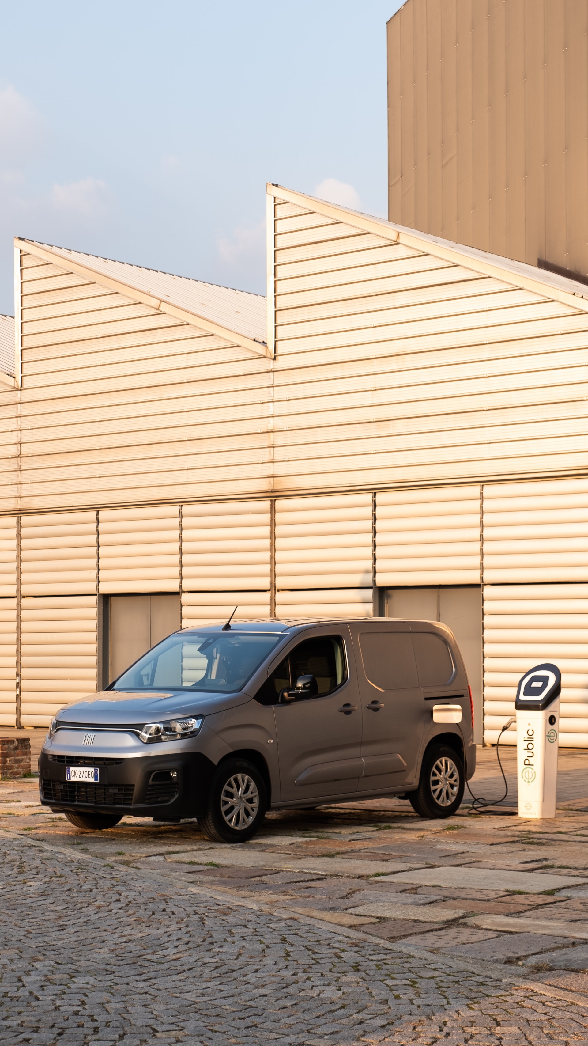 Vista lateral con techo del Fiat Dobló eléctrico mientras se carga.