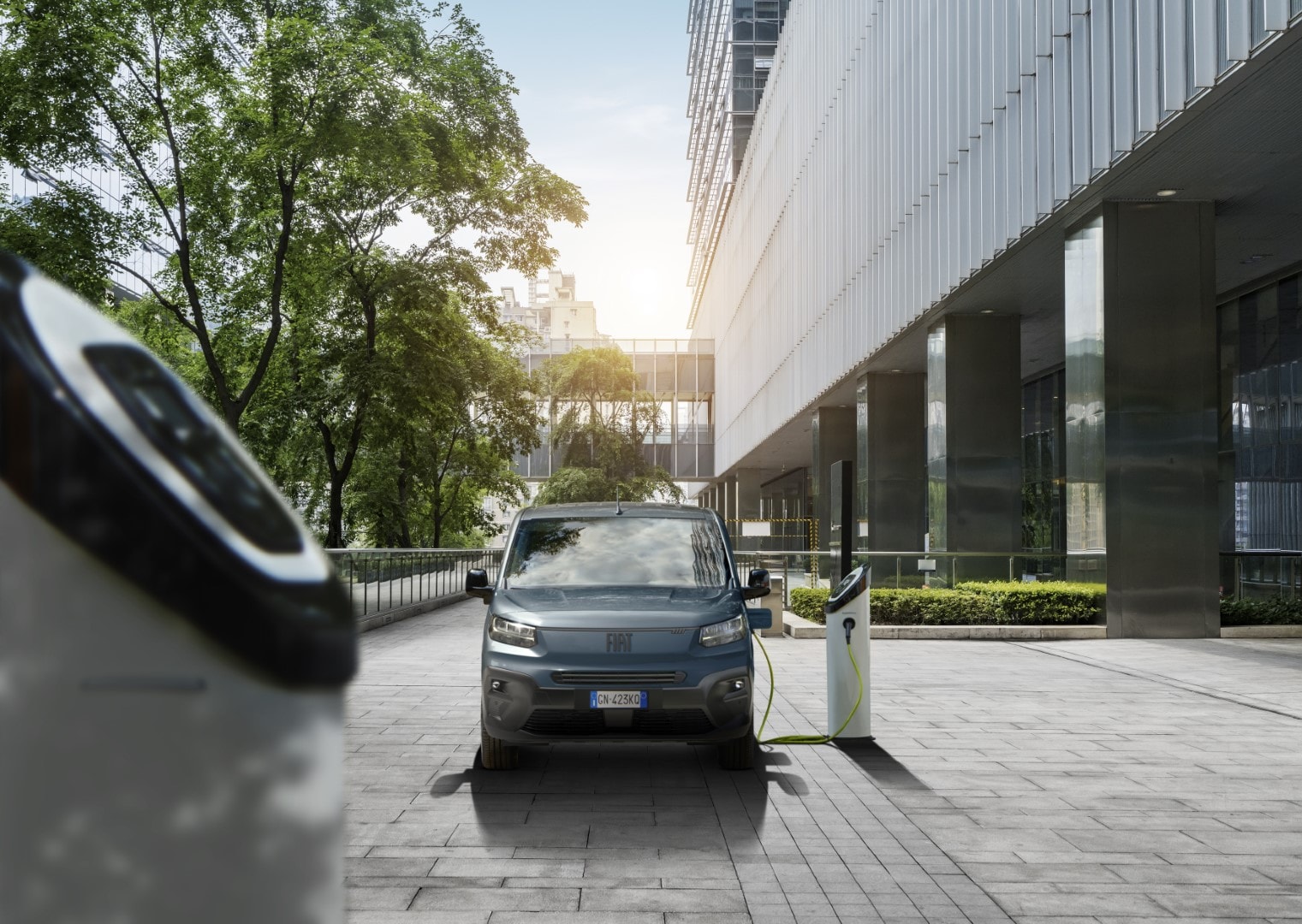Fiat Ducato eléctrico cargando en una estación en el exterior de un edificio.