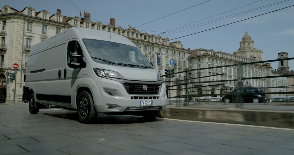 Vista lateral del Fiat Ducato eléctrico circulando por la ciudad. Vista lateral del Fiat Ducato eléctrico circulando por la ciudad.