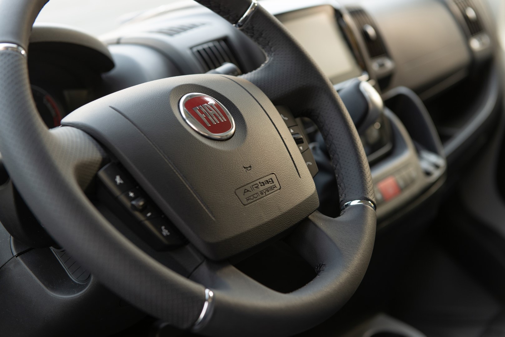 Visión cercana de los instrumentos del Fiat Ducato eléctrico con enfoque en controles de volante.