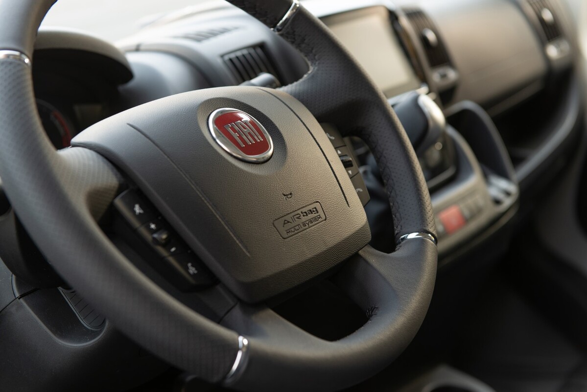 Visión cercana de los instrumentos del Fiat Ducato eléctrico con enfoque en controles de volante. Visión cercana de los instrumentos del Fiat Ducato eléctrico con enfoque en controles de volante.
